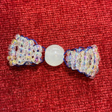 Handcrafted clear and blue glass bead bow charm made by a local artist
