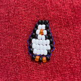 Handcrafted glass bead penguin charm made by a local artist